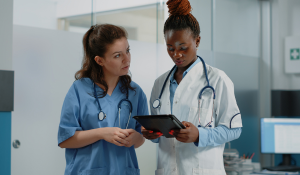 A doctor and a nurse checking patient data on the tablet