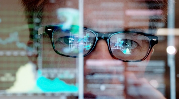 Mann vor dem Computer mit Blick auf die Grafik
