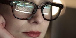 Frau mit Brille vor einem Computer