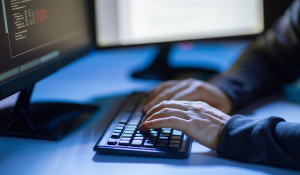Person, die auf einer schwarzen Tastatur tippt