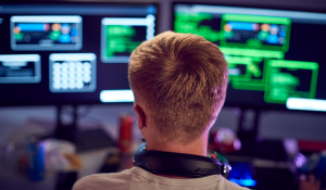 Mann sitzt vor einem Computer bei der Arbeit
