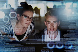 Two people looking on a computer screen with a code