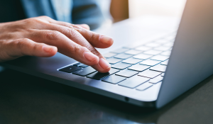 Person writing on the laptop