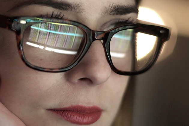 Frau mit Brille vor einem Computer
