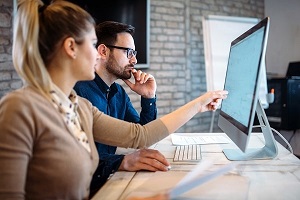 Two people having a meeting in front of a computer